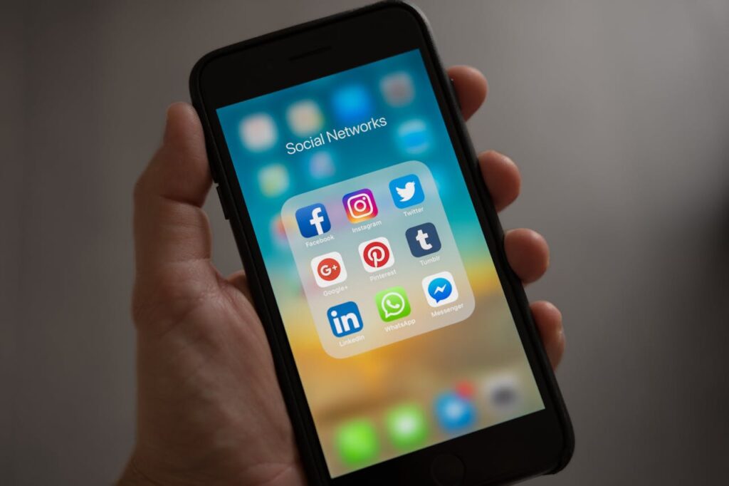 pexels photo 607812 A smartphone displaying various social media icons held in a hand, showcasing modern communication apps.